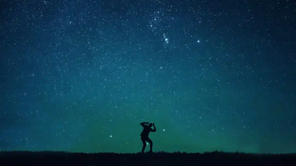 Shadow figure in a fearful pose under a starry sky, hands raised above the head – symbolizing crisis, overwhelm, and a sudden wake-up call in The Last Hour Experience.